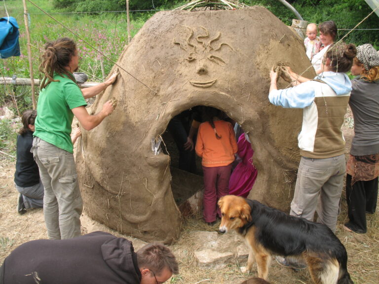 Reliefs und begonnener Feinputz auf einer massiven Strohlehm Wand